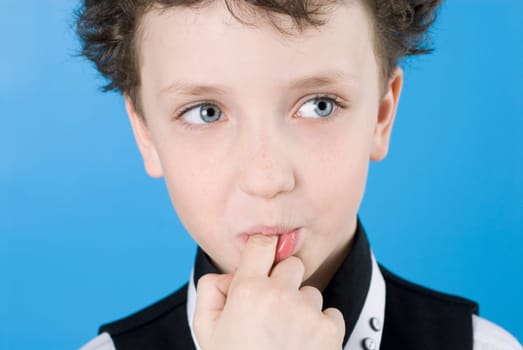 Close_up of a boy with his finger in his mouth