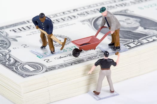 Figurines of manual workers with US paper currency