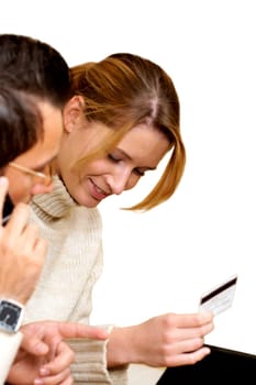 Businesswoman holding a credit card with a businessman talking on a mobile phone beside her