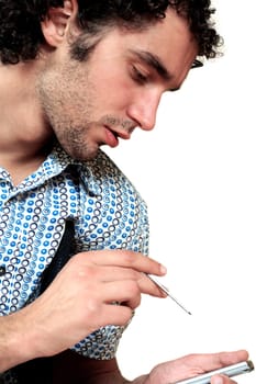 Side profile of a young man operating a personal data assistant