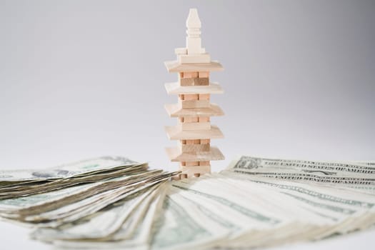 Miniature building with a pile of US paper currency
