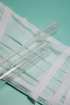 Close_up of a test tube and a pipette on a surgical mask
