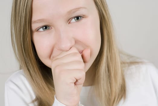 Close_up of a girl smiling with her hands covering her mouth