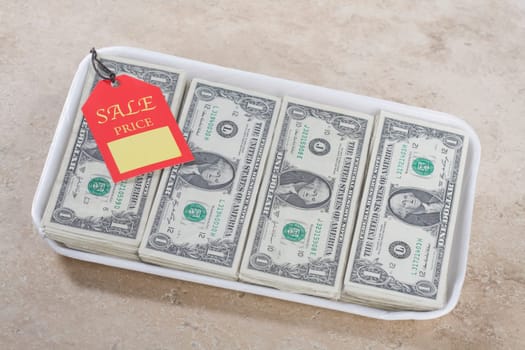 Close_up of a price tag on a container filled with US dollar bills