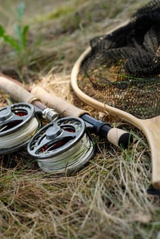 Close-up of two fishing reels and two fishing rods with a fishing net
