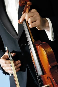 Mid section view of a musician holding a violin and a bow
