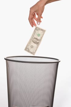 Close_up of a personŽs hand throwing a US dollar bill in a garbage bin