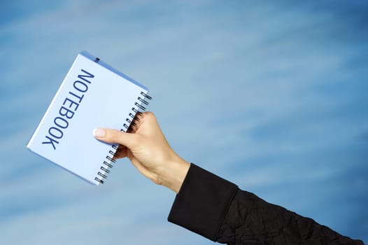 Close-up of a womanŽs hand holding a spiral notebook