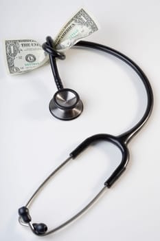 One US dollar bill tied up with a stethoscope
