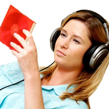Close-up of a businesswoman wearing headphones looking at a CD case
