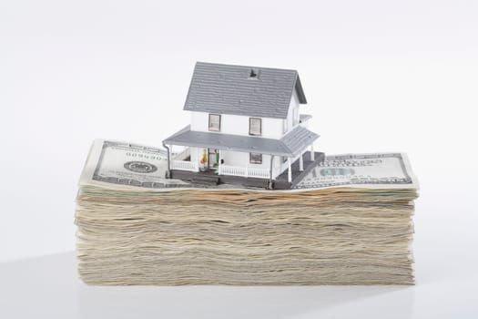 Close_up of a model home on the top of US dollar bills