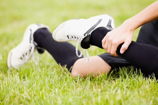 Low section view of a soccer player holding his leg