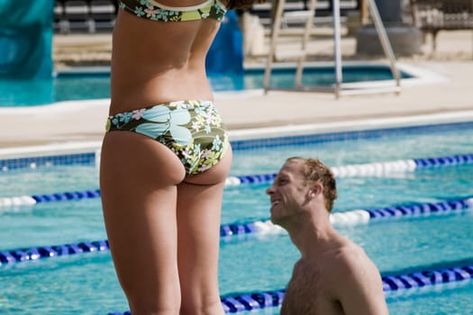 Side profile of a mid adult man in a swimming pool beside a woman