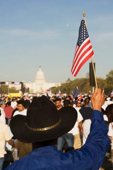 Rear view of a person holding an American flag in front of a government building, California State Capitol Building, California, USA