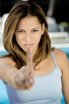 Portrait of a young woman showing her index finger