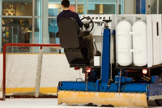 Rear view of a person sitting on an ice resurfacing machine