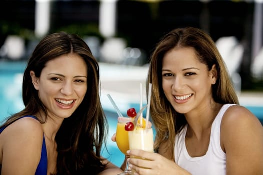 Close-up of two young women holding juice glasses