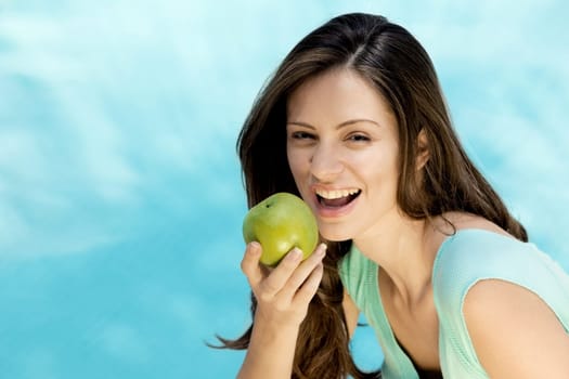 Portrait of a young woman holding an apple
