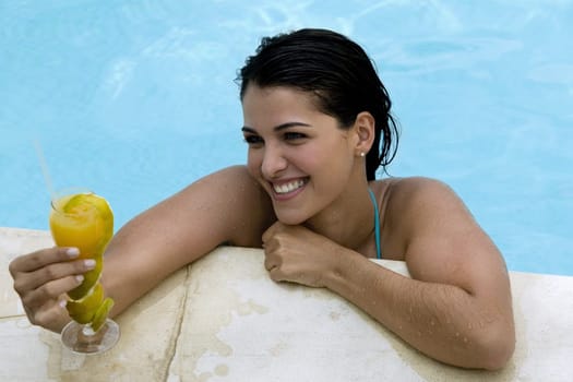 High angle view of a young woman holding a drink in a swimming pool