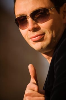 Portrait of a young man showing a thumbs up sign