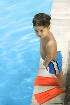High angle view of a boy standing by the pool