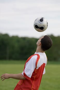 Side profile of a soccer player heading a ball