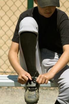 Close-up of a baseball player tying his shoelaces