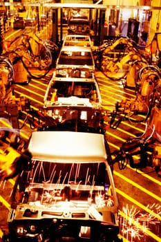 High angle view of robotic arms working on cars in an assembly line, Michigan, Maryland, USA