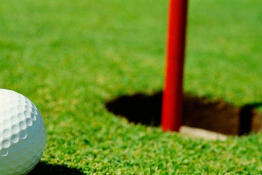 Close-up of a golf ball near a hole