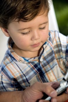 Close-up of a boy looking at a mobile phone