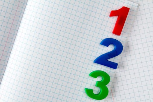 Color plastic numbers on paper exercise book in a cell