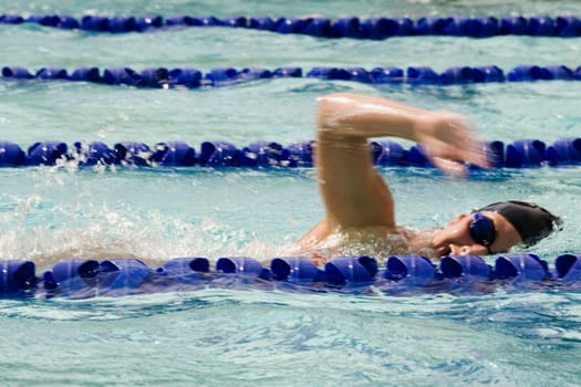 Side profile of a young man swimming in a swimming pool
