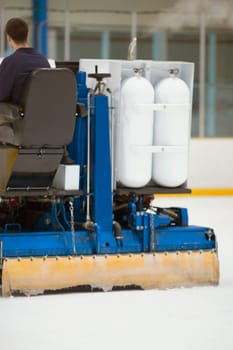 Rear view of a person sitting on an ice resurfacing machine