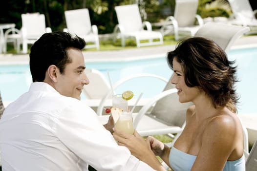 Side profile of a young couple holding drinks