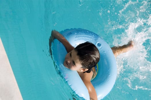 High angle view of a girl swimming with an inflatable ring