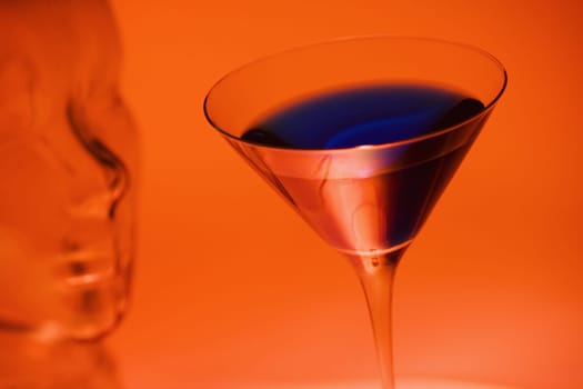 Close-up of a glass of martini near a glass mannequin