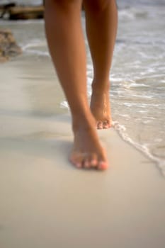 Low section view of a woman walking on the beach