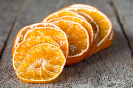 Pile of dry orange slices on the wooden background