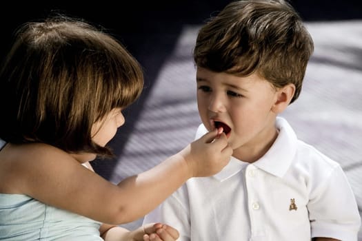 High angle view of a girl feeding nuts to her brother
