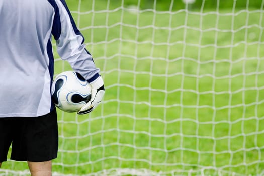 Rear view of a goalie holding a soccer ball
