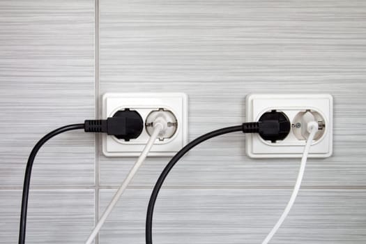 Electrical plugs connected into the wall sockets
