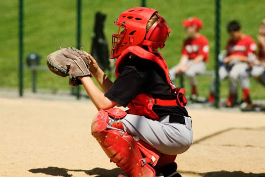 Close-up of a baseball catcher crouching on a baseball field
