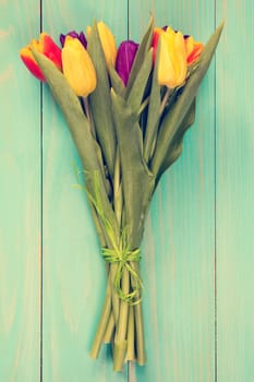 Bouquet of colorful tulips on a wooden background. Spring flowers. Mother's Day background.