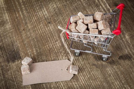 Cane sugar cubes in shopping cart with blank paper tag