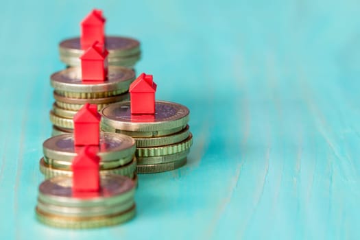 Real estate mortgage concept with small house models on coins row