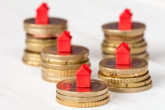 Mini houses and coins stacks. Concept for property ladder, mortgage and real estate investment