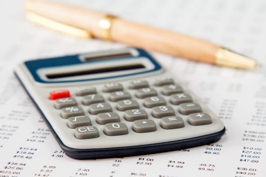 Close-up of a spreadsheet with calculator and pen