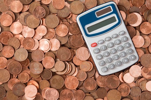 Calculator and heap of euro cent coins of different denominations
