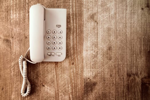 Touch tone telephone on old wooden table. Copy-space.