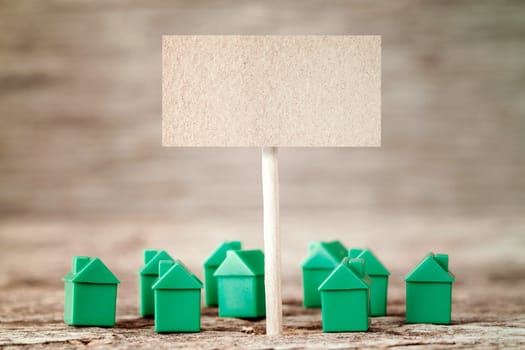 Blank sign with mini green houses,concept for real estate